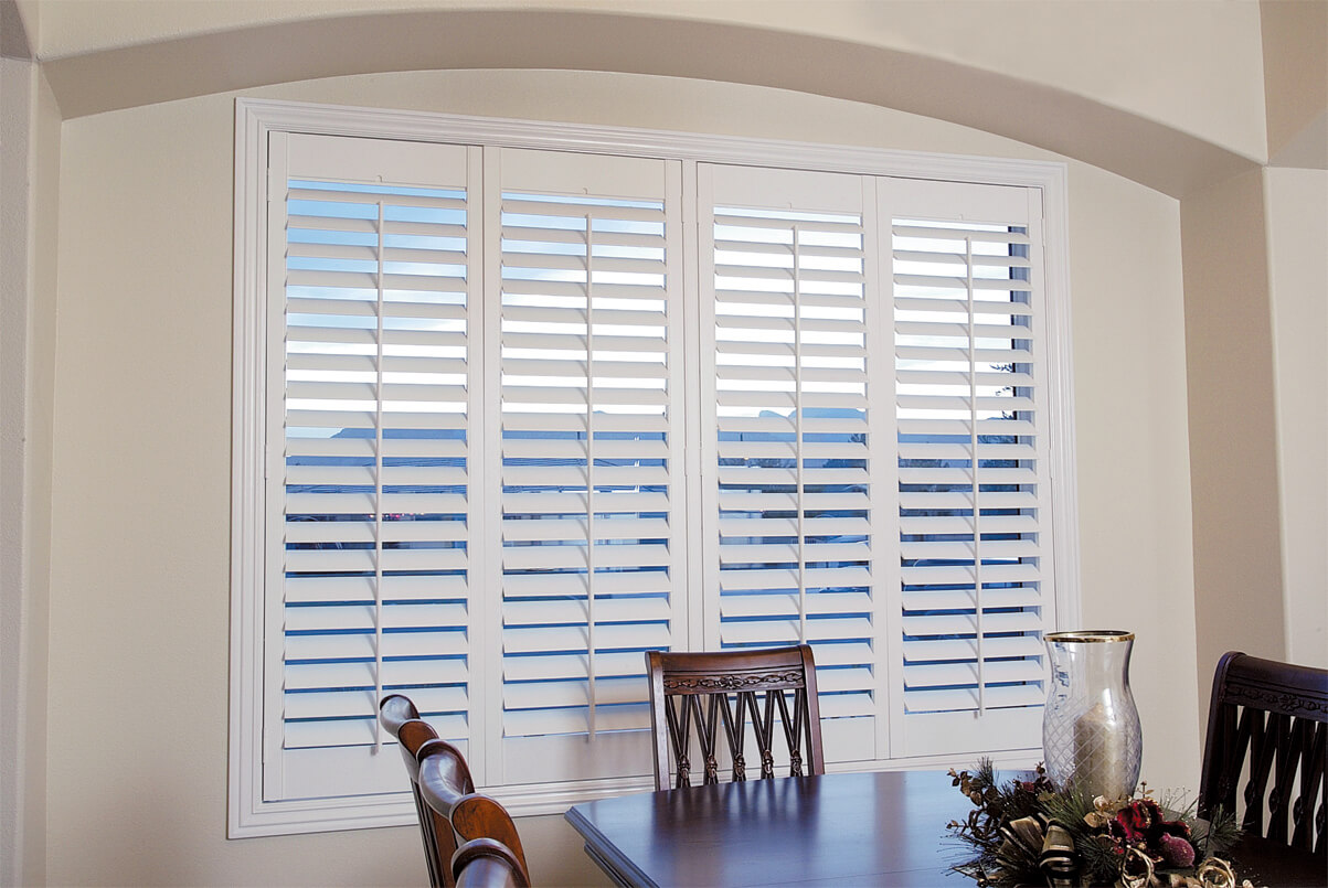 dining room with white wooden blinds on windows